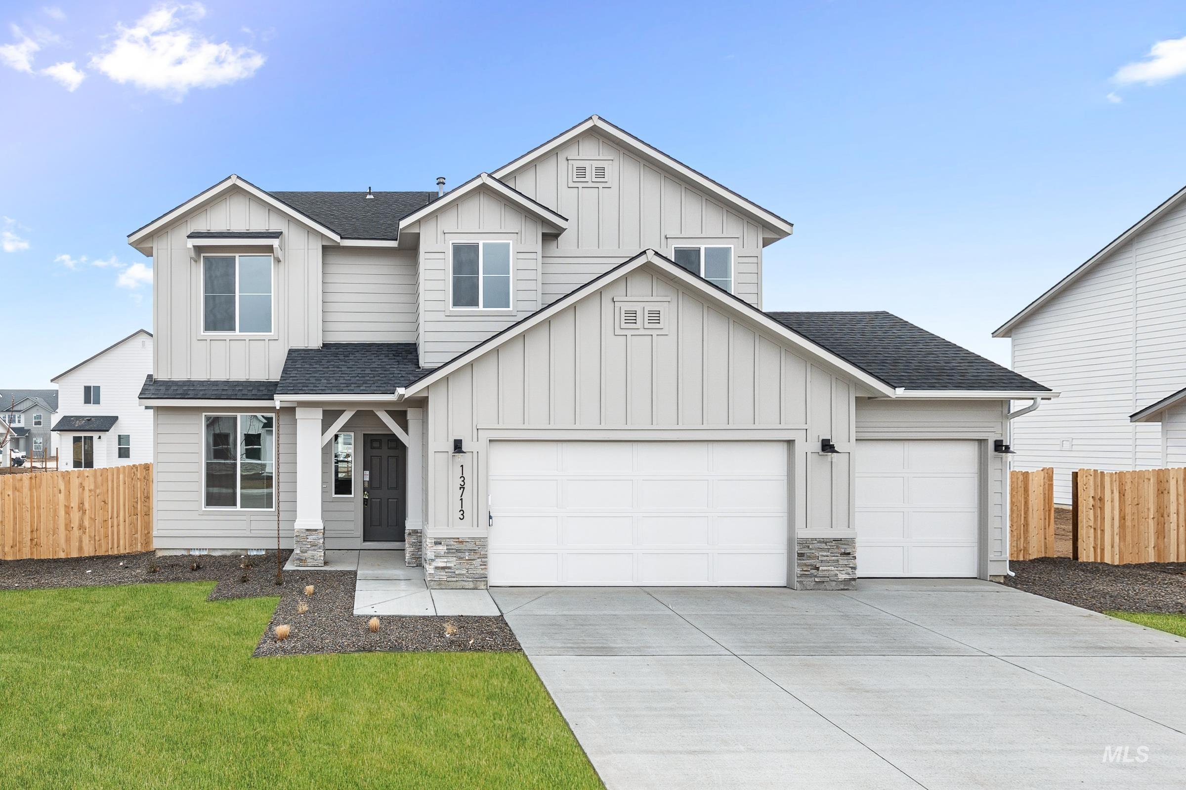 View of front of property with roof with shingles, board and batten siding, an attached garage, and driveway
