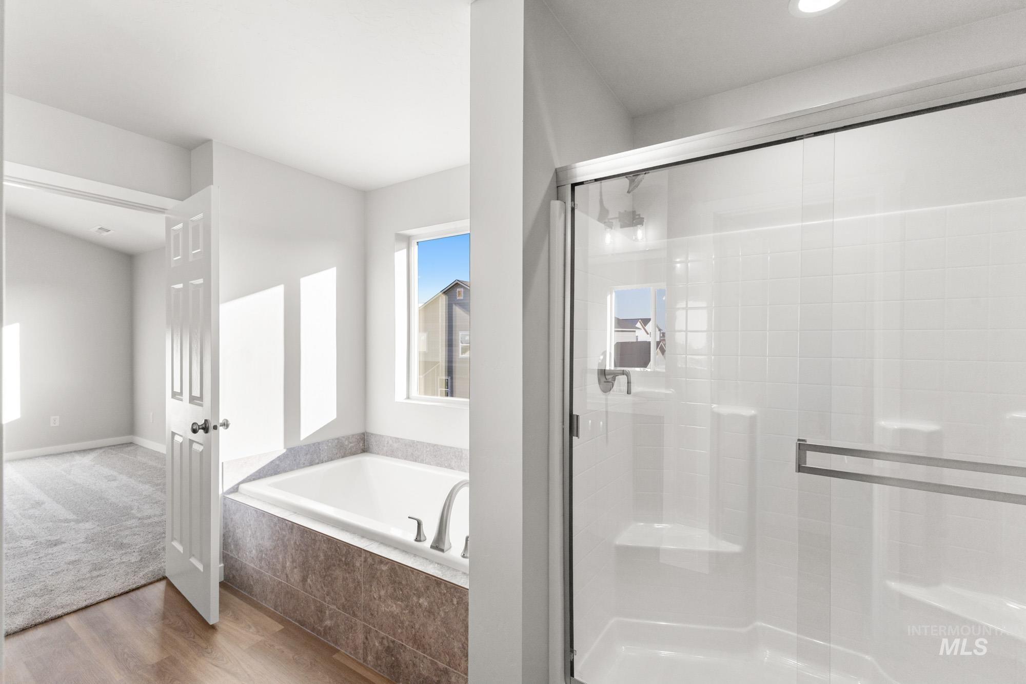13713 Judson Street Caldwell, ID 83607 - Photo 21 of 24 Bathroom featuring a garden tub, wood finished floors, and a shower stall