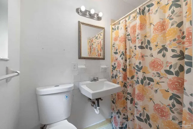 a bathroom with a sink and mirror with toilet