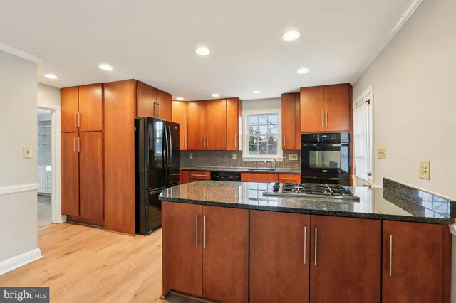 a kitchen with stainless steel appliances granite countertop a sink a stove and a refrigerator