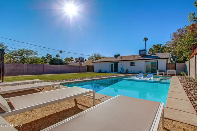 a view of a house with swimming pool and a yard