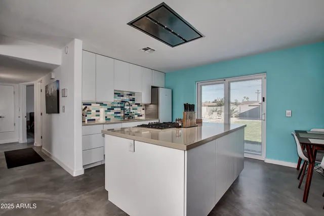 a kitchen with kitchen island a sink appliances and cabinets
