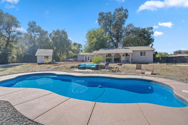 a view of a house with swimming pool and sitting area