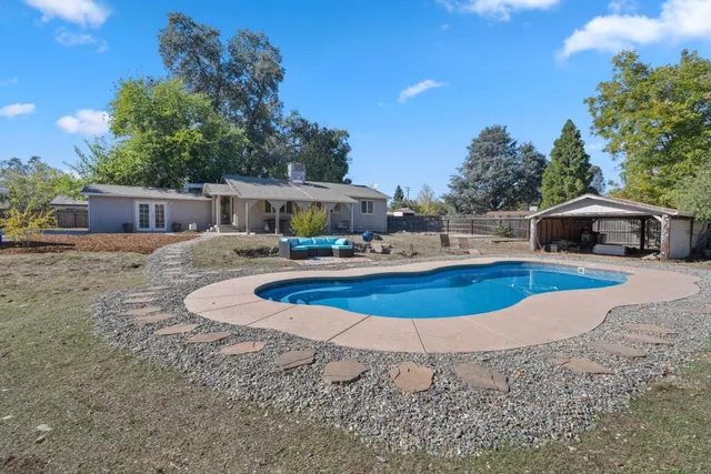 a swimming pool with outdoor seating and yard