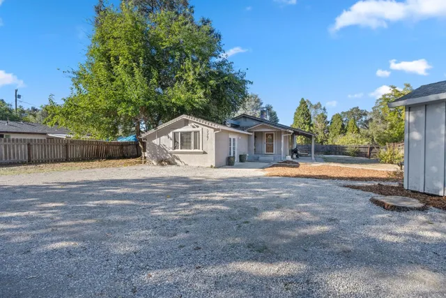 a view of a house with backyard and trees
