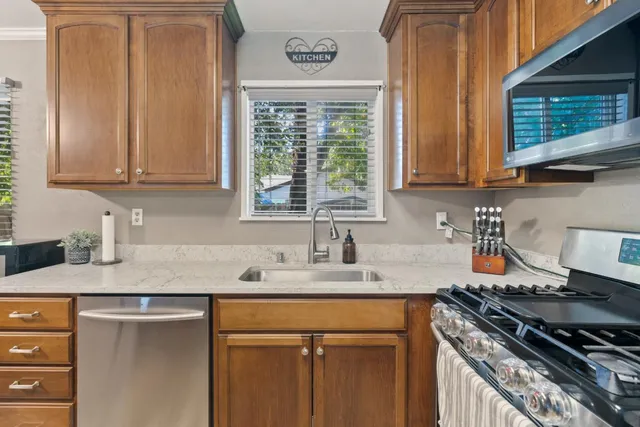 a kitchen with stainless steel appliances granite countertop a sink stove and cabinets