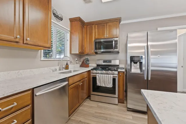 a kitchen with stainless steel appliances granite countertop a refrigerator sink and microwave