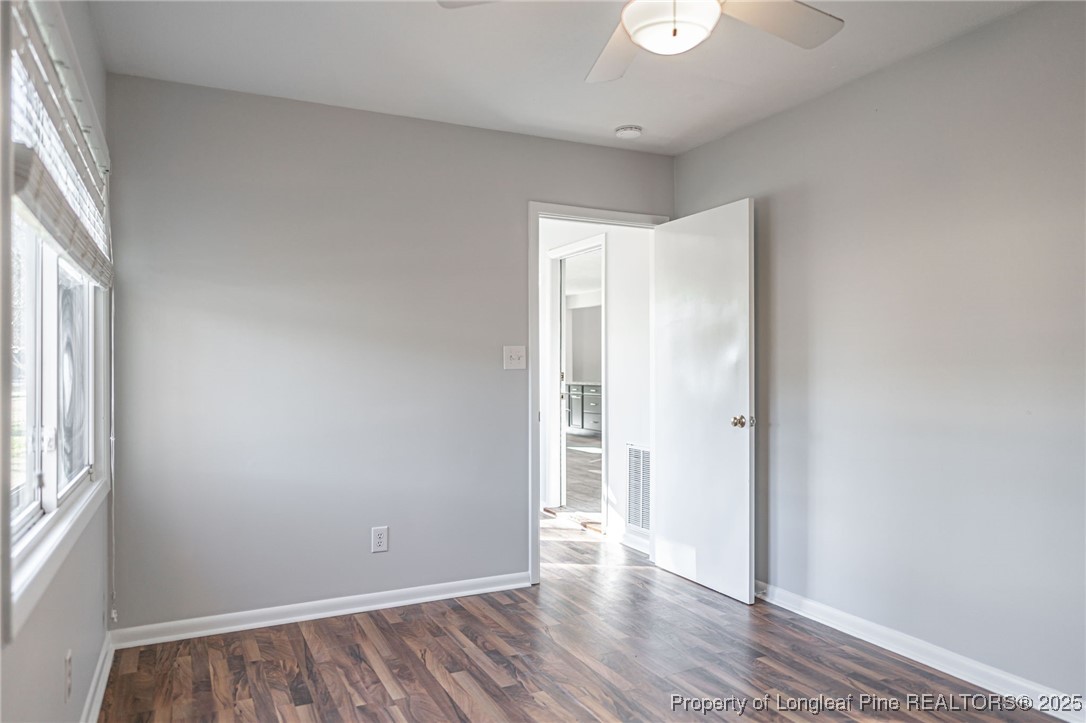 255 Foxcroft Road Whispering Pines, NC 28327 - Photo 17 of 31 an empty room with wooden floor and windows