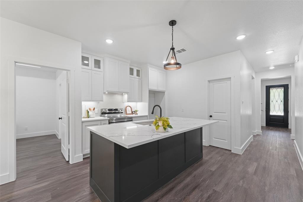 122 East Beachwood Loop Trinidad, TX 75163 - Photo 11 of 35 Modern kitchen featuring white shaker cabinetry, stainless steel appliances, a black kitchen island with a white countertop, and wood-finish flooring