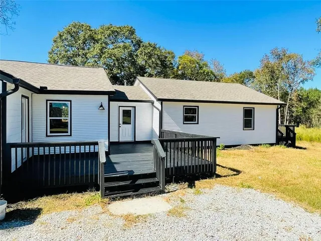 a view of a house with a wooden fence in front of house