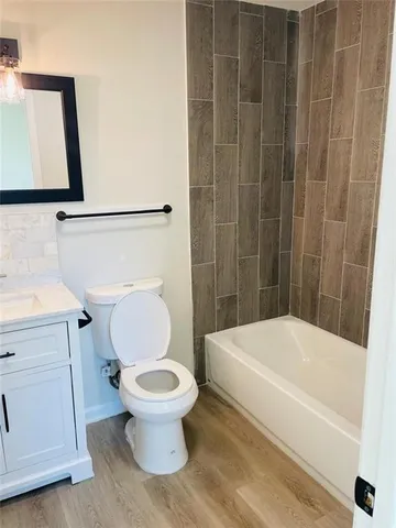 a white toilet sitting next to a bath tub