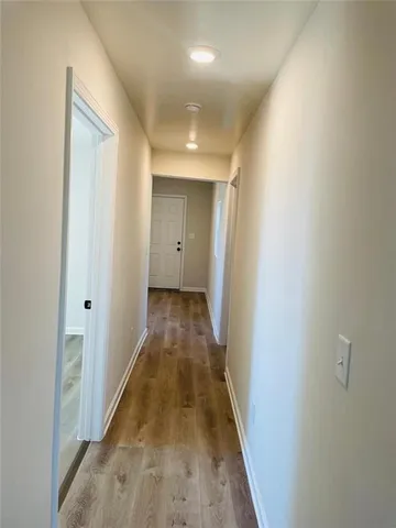 a view of a hallway with wooden floor