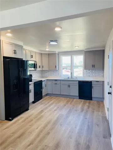 a large kitchen with stainless steel appliances granite countertop a stove a sink dishwasher and a refrigerator