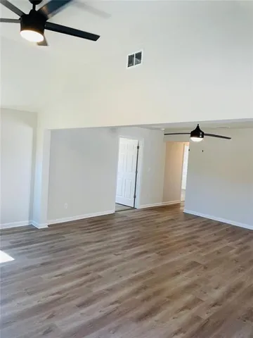 a view of an empty room with wooden floor
