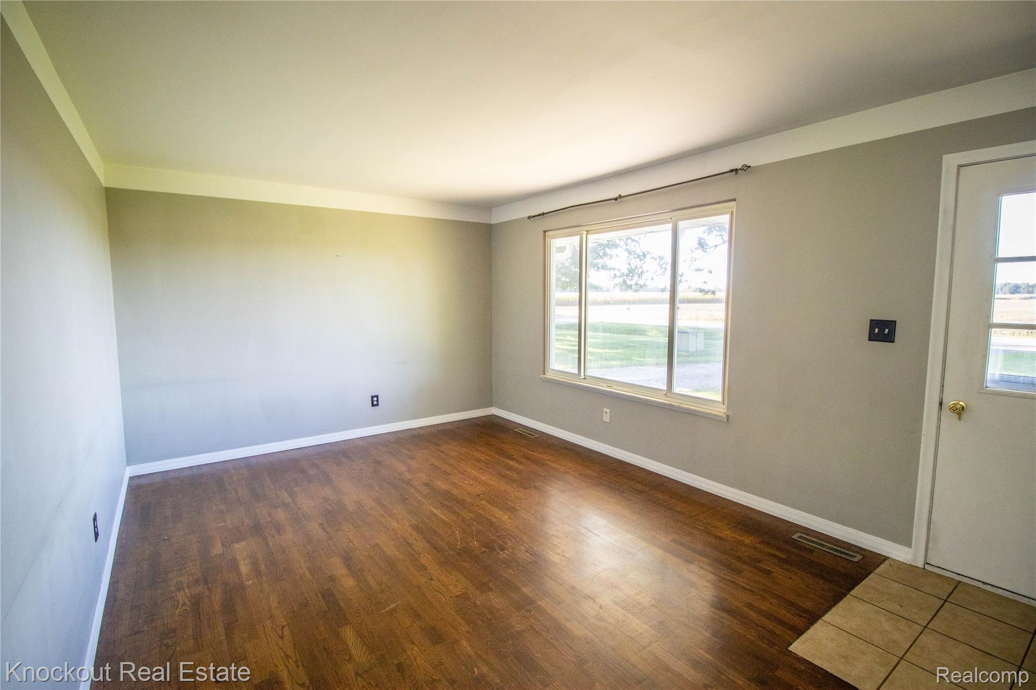 5796 East Burt Road Birch Run, MI 48415 - Photo 3 of 41 Wood-finish flooring, neutral wall tones, and a large window