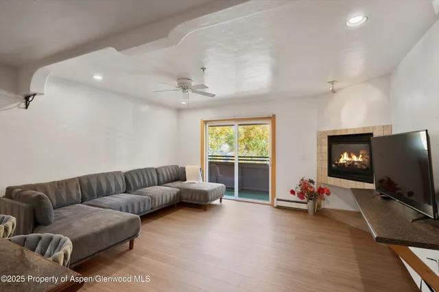 a living room with furniture a flat screen tv and a window