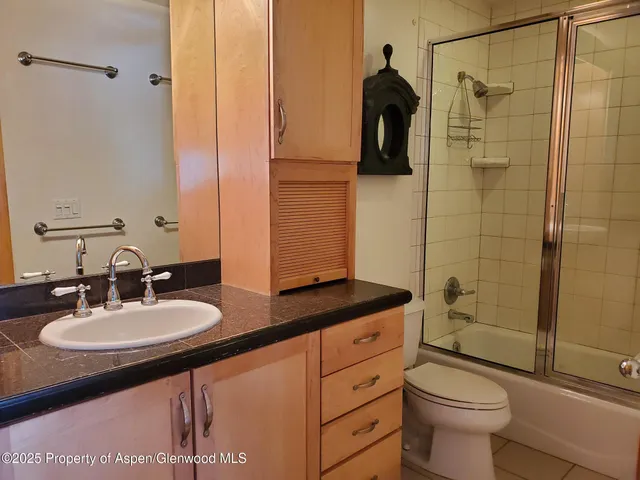 a bathroom with a sink toilet a mirror and shower