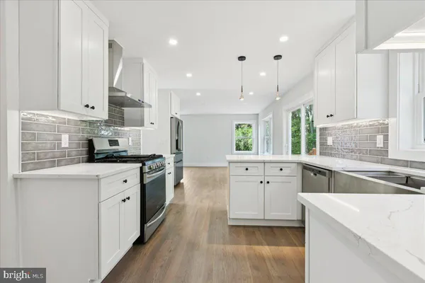 a kitchen with white cabinets appliances and a sink
