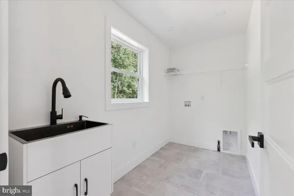 a view of a sink storage and utility room with a window