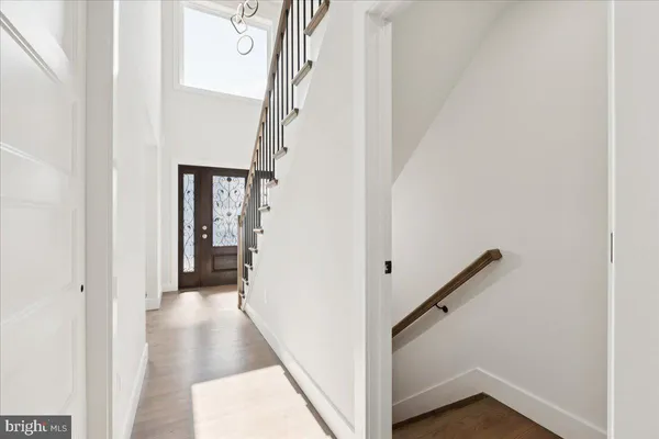 a view of a hallway with wooden floor and entryway