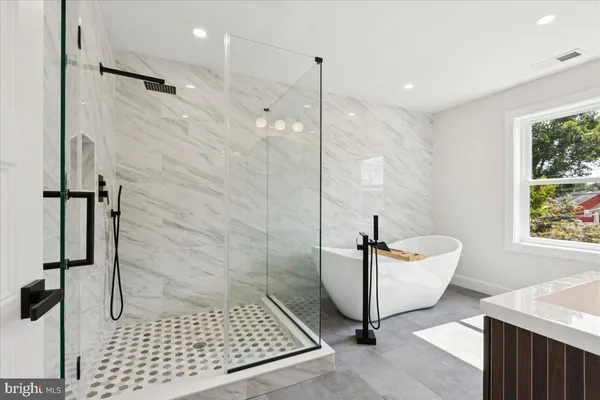 a bathroom with a sink a toilet a mirror and shower