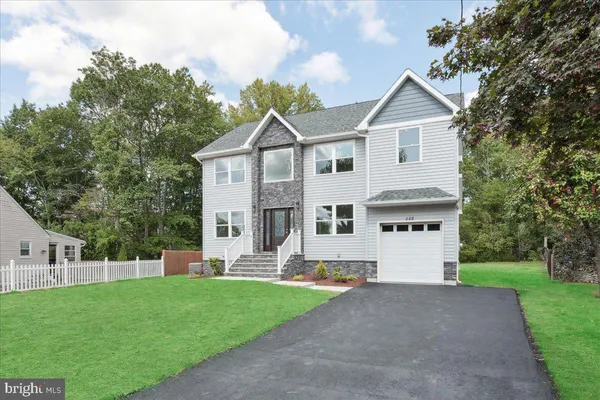 a front view of a house with a yard and trees