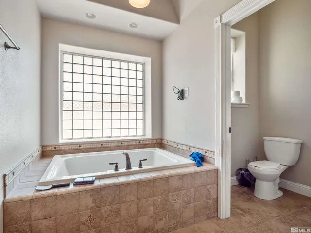 a spacious bathroom with a granite countertop sink a mirror and a