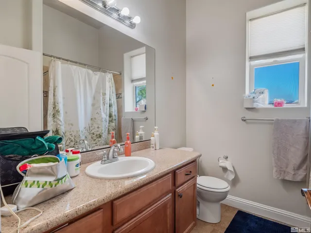 a bathroom with a toilet a sink and mirror