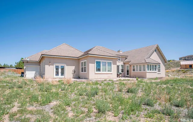 a view of a house with backyard and sitting area