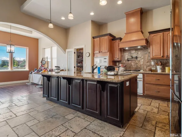 a kitchen with stainless steel appliances granite countertop a stove a sink and a refrigerator