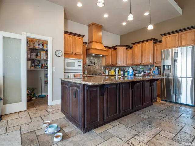 a kitchen with stainless steel appliances granite countertop a refrigerator and a stove