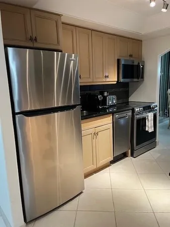 a kitchen with stainless steel appliances granite countertop a sink and a refrigerator