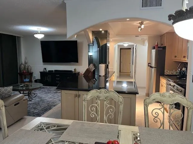 a kitchen with stainless steel appliances granite countertop a sink and a refrigerator
