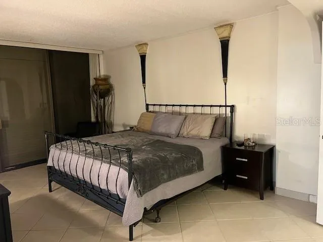 a bedroom with a bed and a flat tv screen on dresser