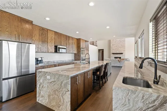 a kitchen with stainless steel appliances granite countertop a sink refrigerator and cabinets
