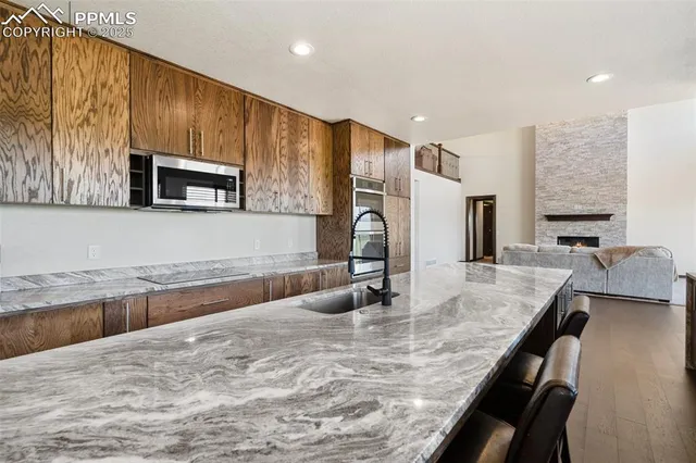 a kitchen with granite countertop a sink stainless steel appliances and cabinets