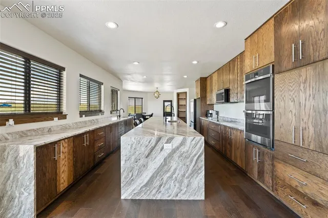 a large kitchen with kitchen island granite countertop a large center island and stainless steel appliances