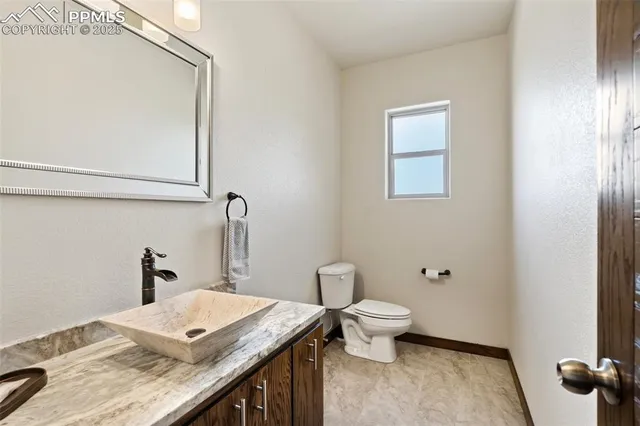 a bathroom with a granite countertop sink a toilet and a mirror