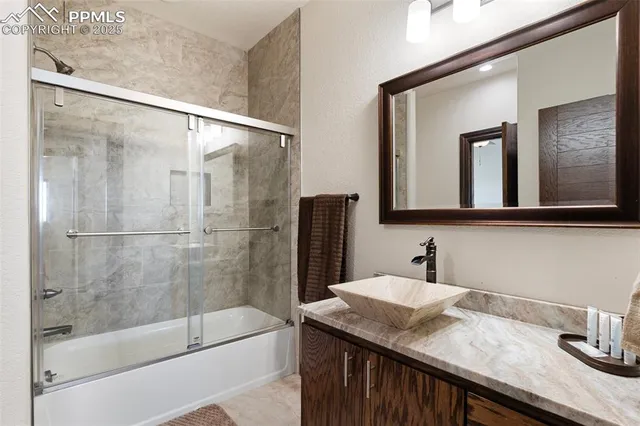 a bathroom with a granite countertop sink mirror and a bathtub