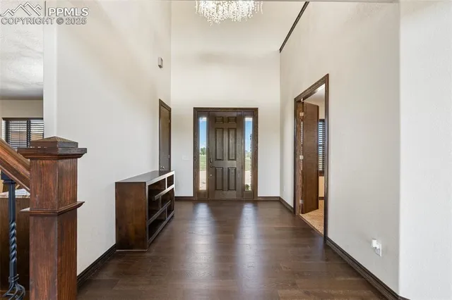 a view of a hallway to a livingroom with wooden floor and furniture