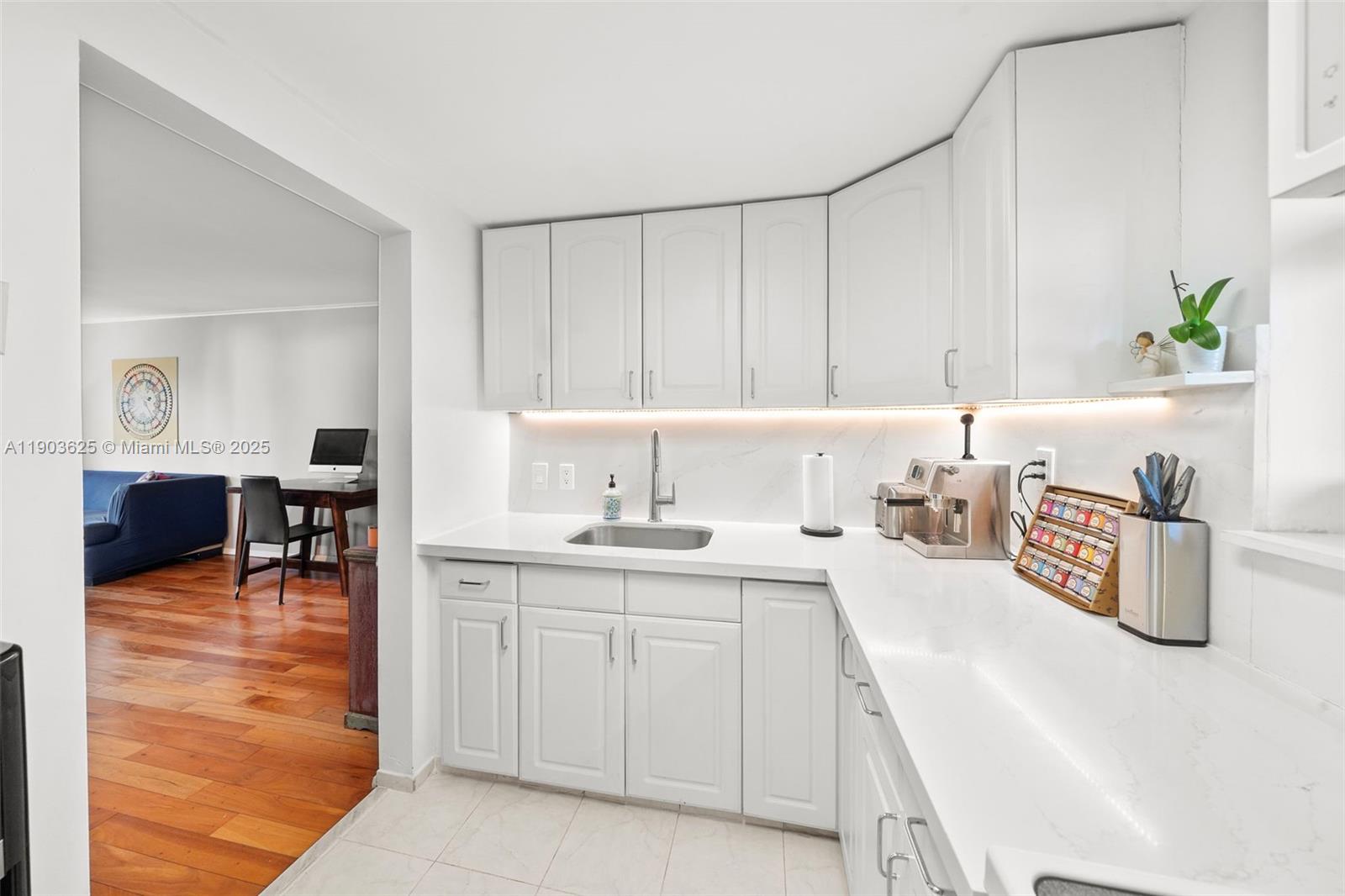 1674 Bay Road, Unit 401 Miami Beach, FL 33139 - Photo 13 of 33 a kitchen with a sink and cabinets