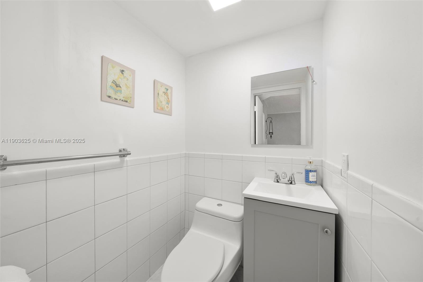 1674 Bay Road, Unit 401 Miami Beach, FL 33139 - Photo 22 of 33 a bathroom with a toilet sink and mirror