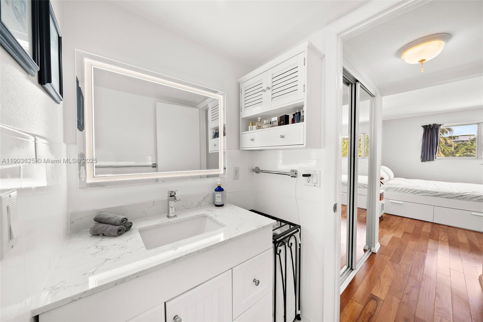 1674 Bay Road, Unit 401 Miami Beach, FL 33139 - Photo 26 of 33 a en suite bathroom with a sink and a mirror