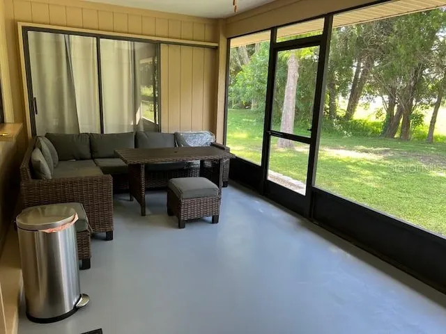 a living room with furniture and a floor to ceiling window