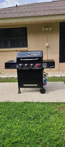 a view of backyard with table and chairs and barbeque grill