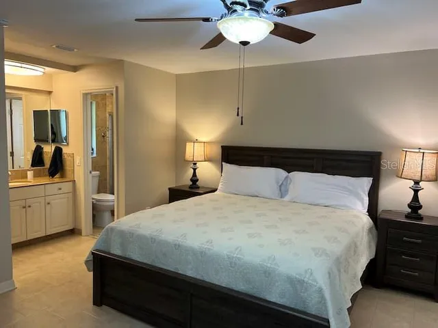 a bedroom with a large bed and a chandelier