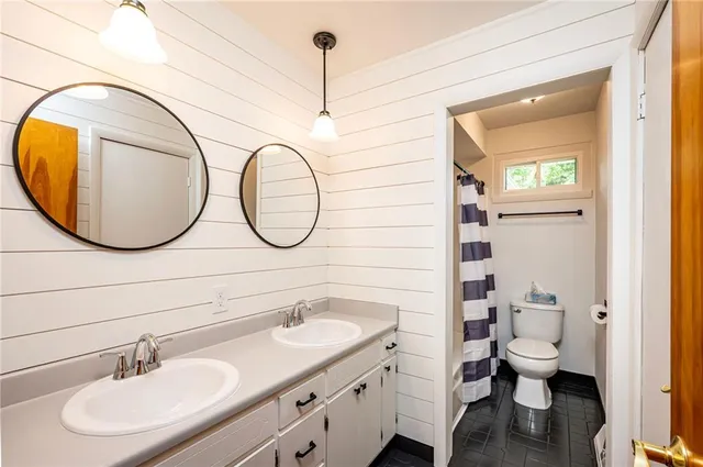 a bathroom with a sink a toilet and a mirror