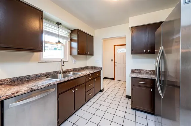 a kitchen with stainless steel appliances granite countertop a refrigerator and a sink