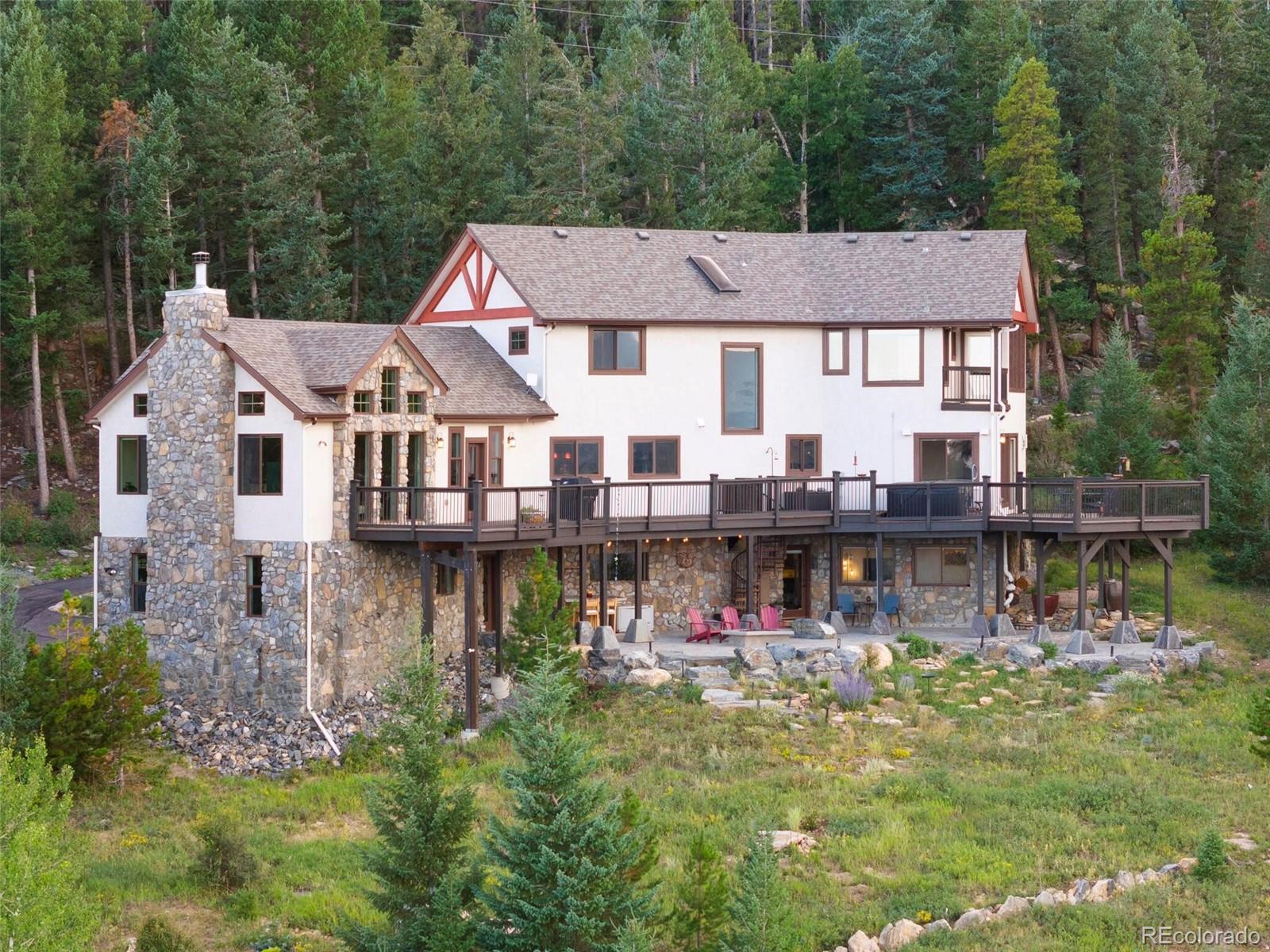 913 Saddle Ridge Drive Evergreen, CO 80439 - Photo 1 of 50 a aerial view of a house with swimming pool and a yard
