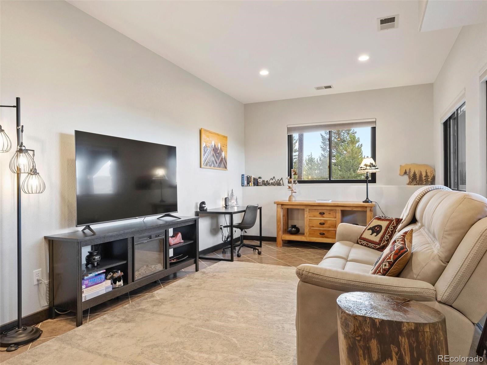 913 Saddle Ridge Drive Evergreen, CO 80439 - Photo 37 of 50 a living room with furniture and a flat screen tv